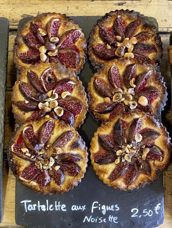 Tartelettes aux fruits alignées dans la vitrine de la boulangerie.